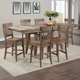 A rustic 7-piece counter height dining table set with a rectangular wooden table and six matching slatted-back stools, shown in a bright dining room setting.