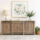 Wooden sideboard with decorative items including a lamp, framed artwork, and plants in a room.