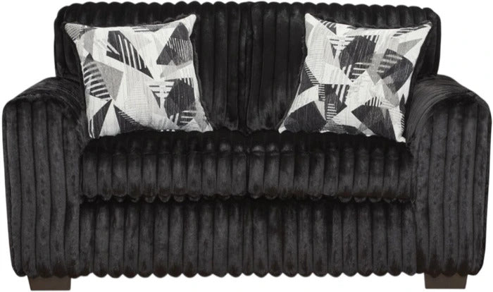 A black ribbed velvet loveseat sofa with two square throw pillows featuring a black, white, and gray geometric pattern, shown against a plain white background.