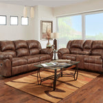 Brown leather reclining sofa and matching loveseat in a bright living room with wood floors, a glass-top coffee table, and a patterned area rug.