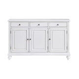 A white wooden sideboard cabinet with three drawers on top and three paneled doors below, featuring small round silver knobs and turned feet, shown against a plain white background.
