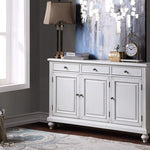 White sideboard in a room with decor elements like a lamp, clock, and decorative items.