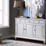 White sideboard in a room with decor elements like a lamp, clock, and decorative items.