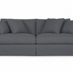 A dark gray fabric slipcovered loveseat sofa with matching back cushions and armrests, shown from a front-facing angle on a plain white background.