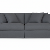 A dark gray fabric slipcovered loveseat sofa with matching back cushions and armrests, shown from a front-facing angle on a plain white background.