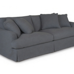 A dark gray slipcovered loveseat sofa with matching throw pillows, shown from a three-quarter angle on a white background.