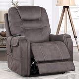 A gray-brown power recliner chair with a footrest extended, shown in a styled living room setting with a tripod floor lamp, shelving, and a window.