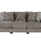 A three-seat upholstered sofa in a textured taupe-gray fabric, styled with five decorative throw pillows in gray and white geometric patterns, set against a plain white background.