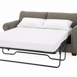 A gray upholstered sofa bed with a pulled-out white mattress and two white pillows, shown on a clean white background.