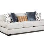 A light beige upholstered loveseat sofa with dark wooden feet, styled with five decorative throw pillows including two navy blue velvet pillows, a tan and white striped pillow, and two white floral patterned pillows, shown against a plain white background.