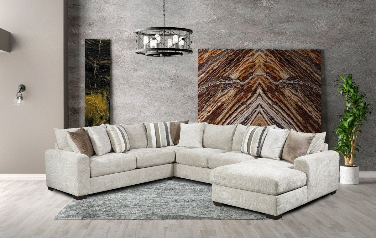 Modern living room with a sectional sofa, artwork on the wall, and a plant.
