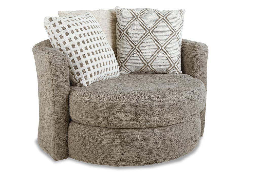 A round upholstered accent chair in textured taupe fabric, featuring two decorative throw pillows with geometric patterns, set against a plain white background.