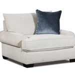 A light beige upholstered armchair with a dark blue velvet accent pillow, shown on a plain white background.