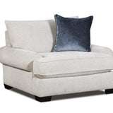 A light beige upholstered armchair with a dark blue velvet accent pillow, shown on a plain white background.