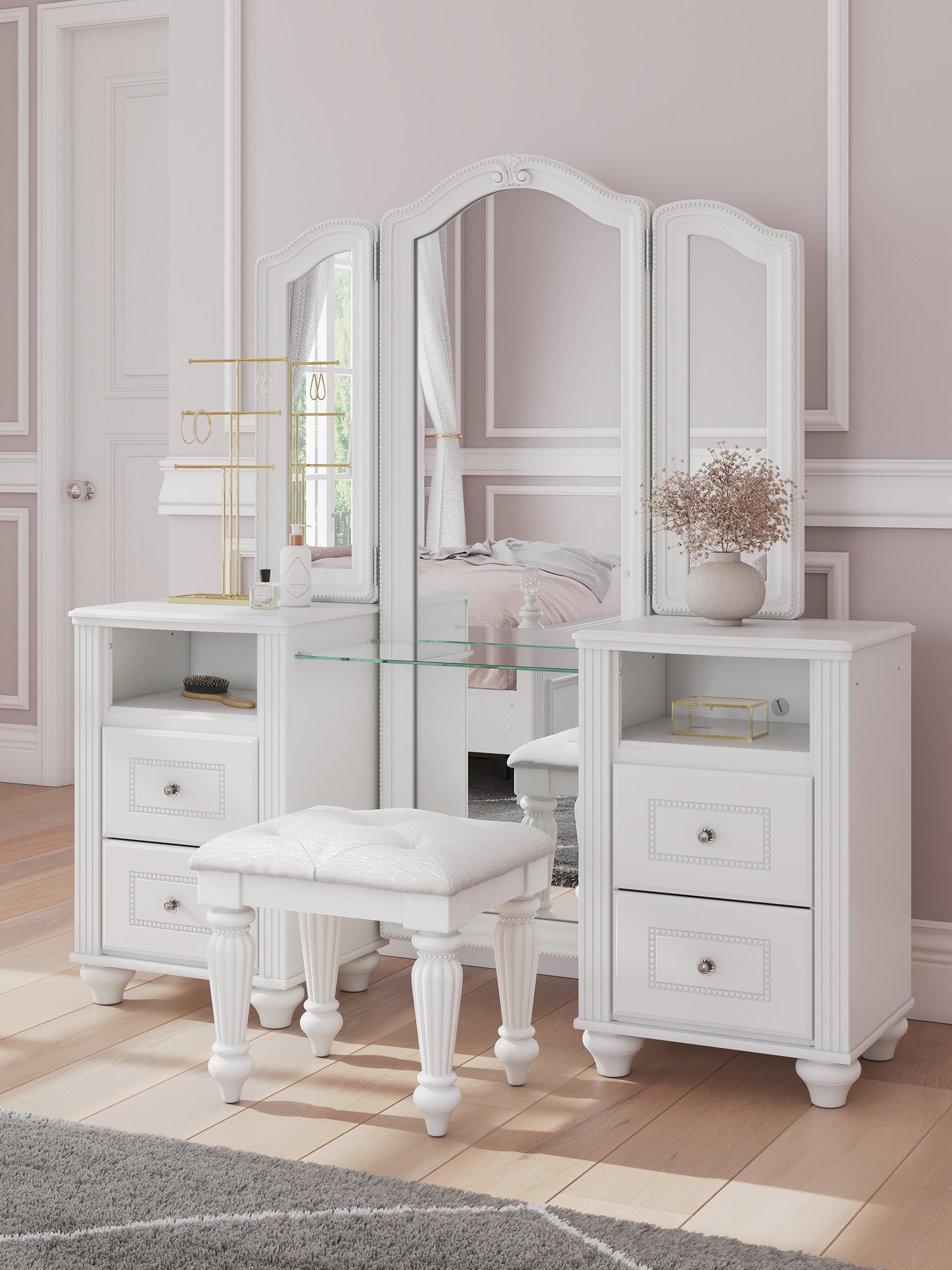 White vanity table set with a three-panel mirror, glass shelf, drawers, and a matching white stool in a softly styled bedroom interior.