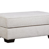 A rectangular upholstered ottoman with a textured light beige fabric and dark block feet, shown on a plain white background.