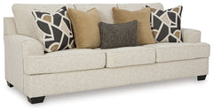 Living room with a beige sofa, decorative pillows, and two lamps.