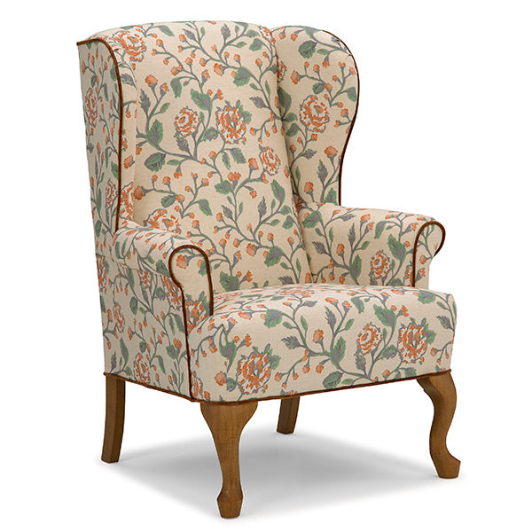 Floral-patterned armchair with wooden legs on a white background