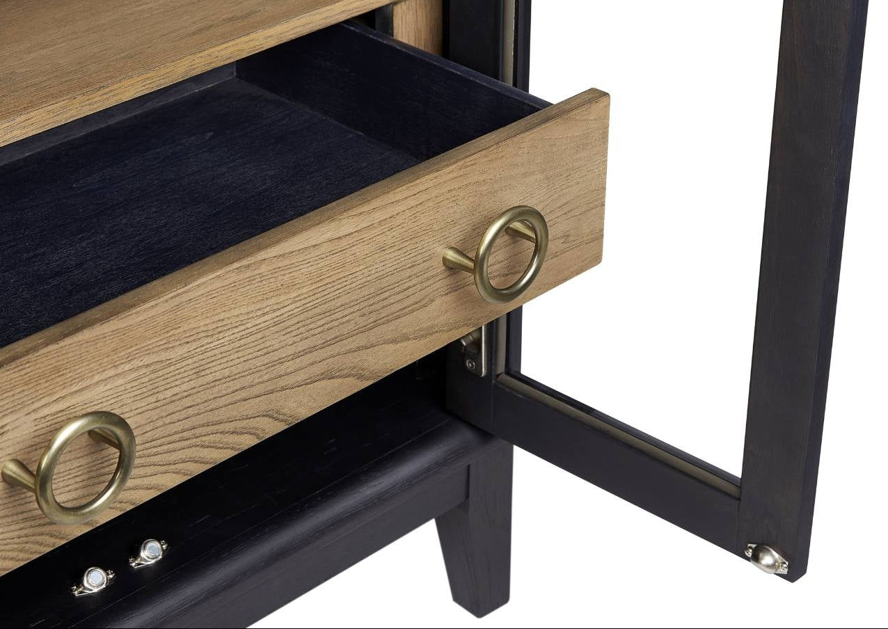 Close-up of a black wooden cabinet with an open door and a partially pulled-out drawer, showing light oak wood interior, a dark velvet lining, and brass ring pulls on a white background.