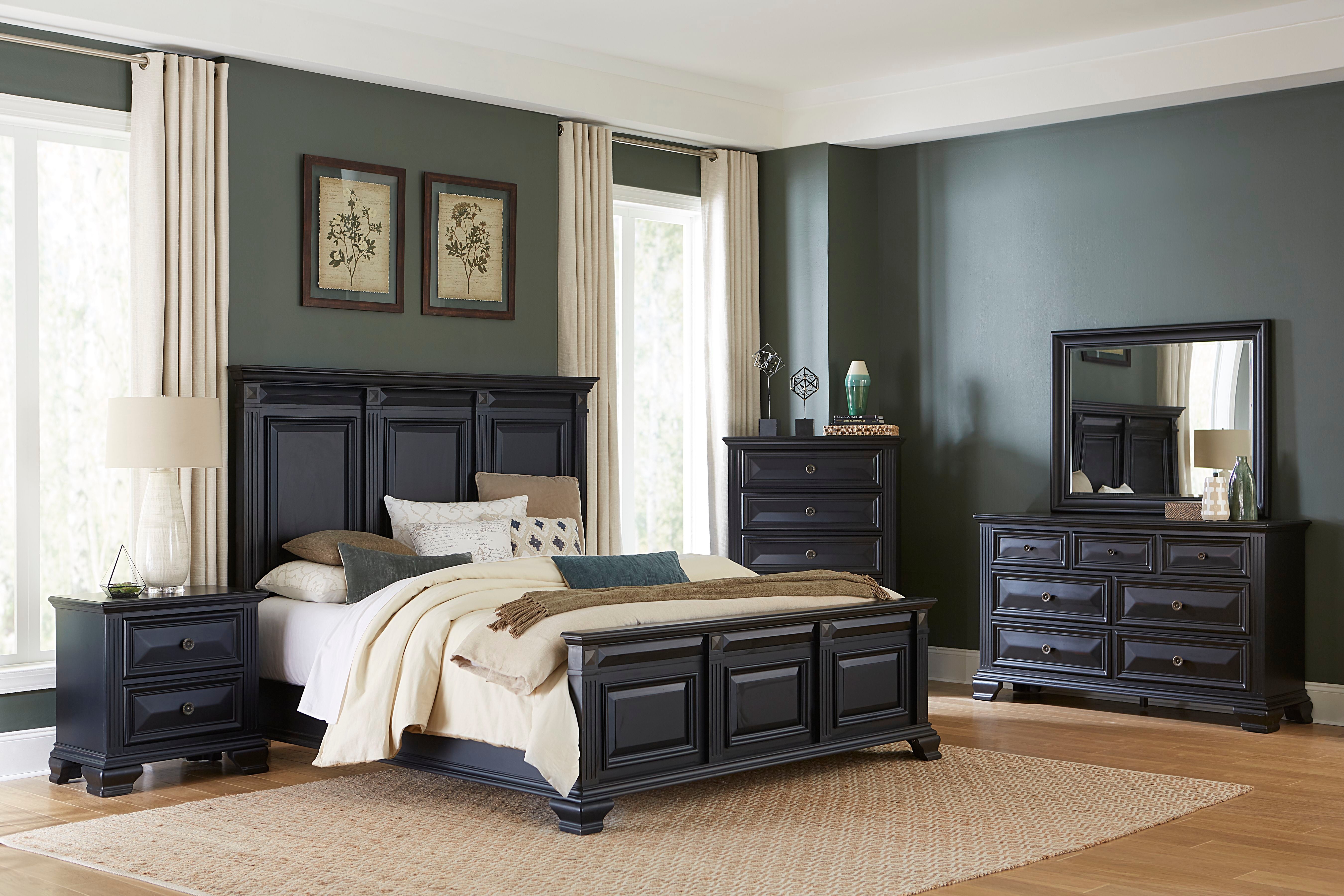 A 7-piece bedroom furniture set in a dark charcoal gray finish, including a bed frame with a paneled headboard, a nightstand, a dresser, a chest, and a matching mirror, styled in a modern bedroom with dark gray walls and beige curtains.