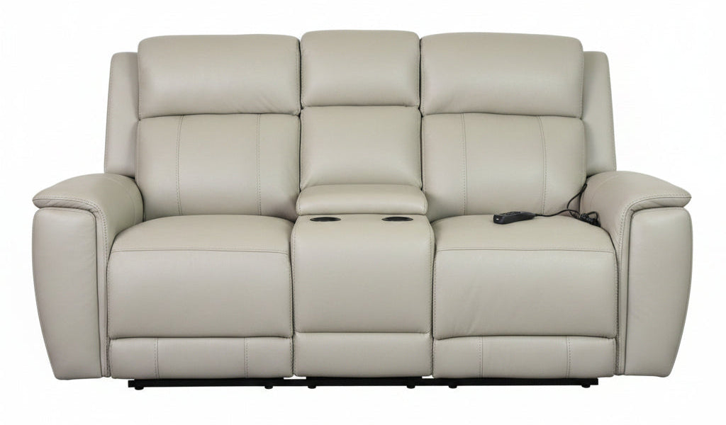 A light beige leather reclining sofa with a console with built-in remote controls on the seat and armrests, shown against a plain white background.