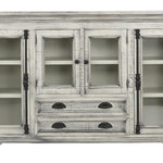 A distressed white wood accent cabinet with glass-front upper doors, open shelves, and two lower drawers with dark metal pulls, shown on a plain white background.