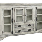 A distressed white wood sideboard cabinet with glass-front upper doors, open shelves, and three drawers with dark metal pulls, shown on a plain white background.