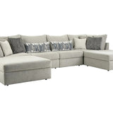 A light gray fabric sectional sofa with a chaise lounge on the left and a right-facing chaise, styled with multiple throw pillows including gray and patterned accent pillows, shown against a plain white background.