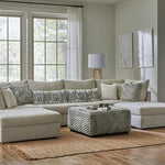 Modern living room with a beige sectional sofa, coffee table, and decorative pillows.