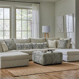 Modern living room with a beige sectional sofa, coffee table, and decorative pillows.