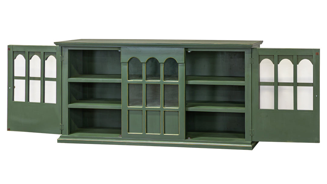 A green wooden sideboard cabinet with its doors open, featuring glass-paneled doors with arched tops and multiple interior shelves, shown against a plain white background.