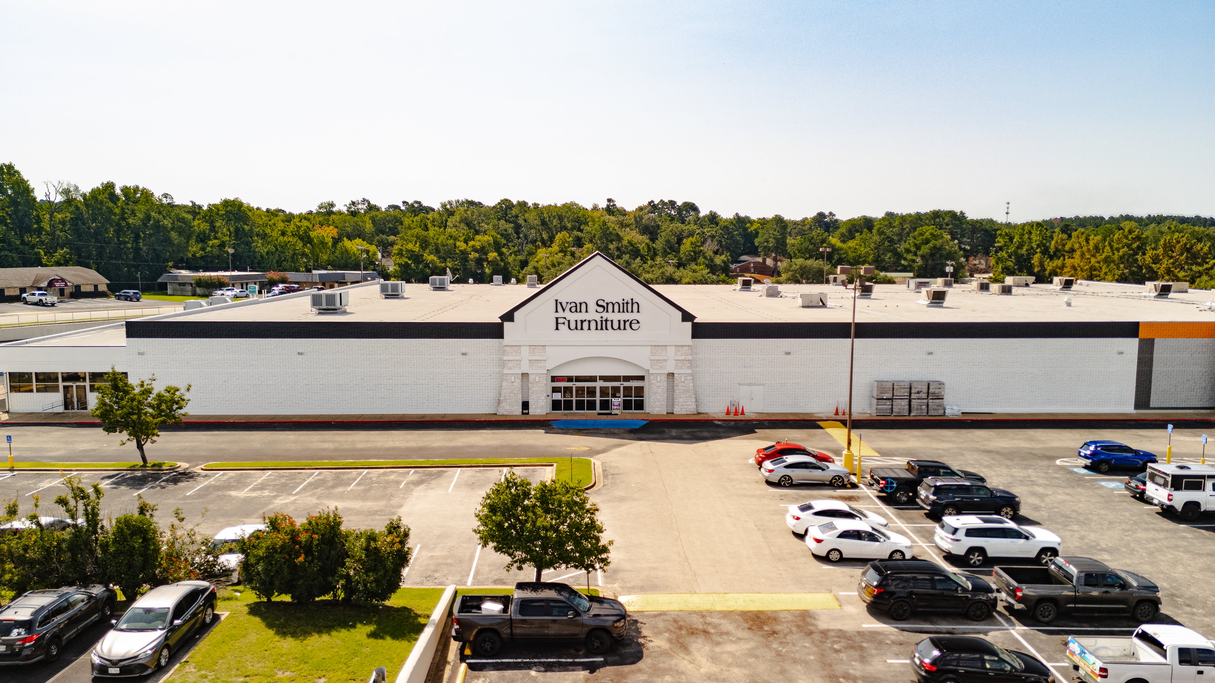 Ivan Smith Furniture store in Tyler, TX with a parking lot and trees in the background

